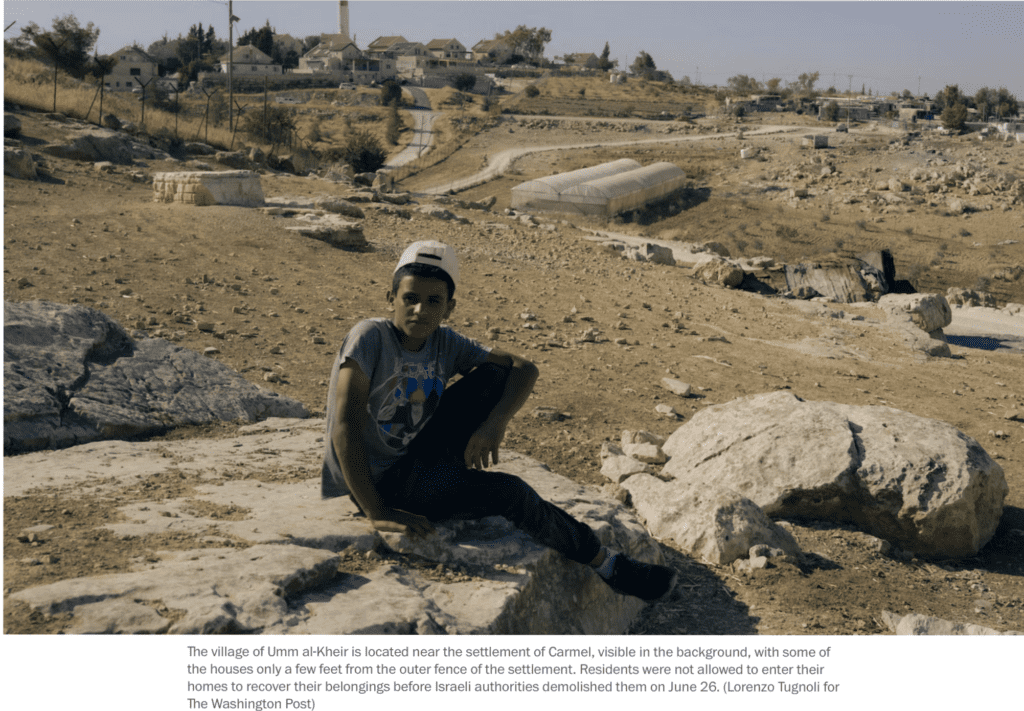 Washington Post - A Palestinian boy sitting on a rock with an illegal Israeli settlement in the distance in Palestine